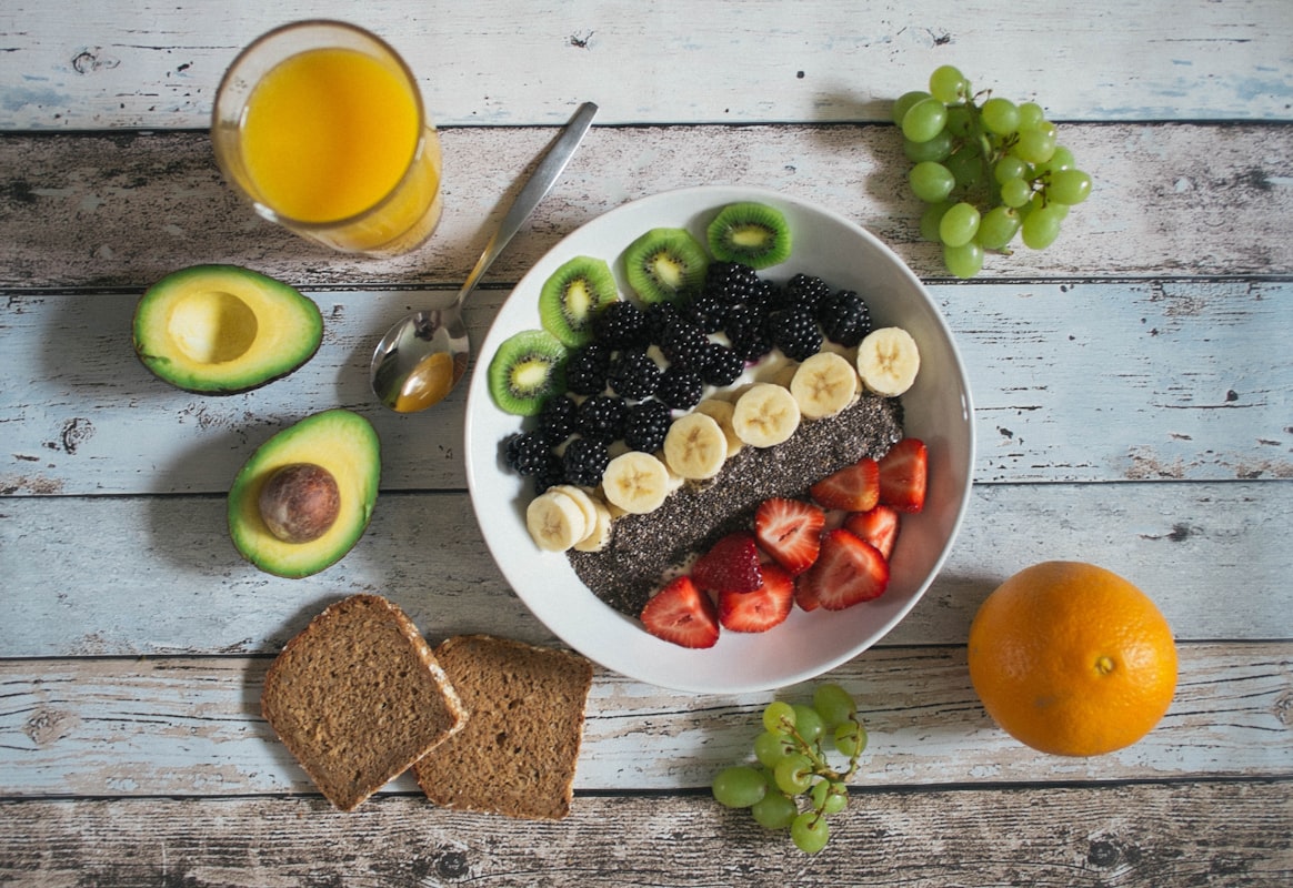 Varietà di alimenti salutari come verdure colorate, frutta fresca e cereali integrali